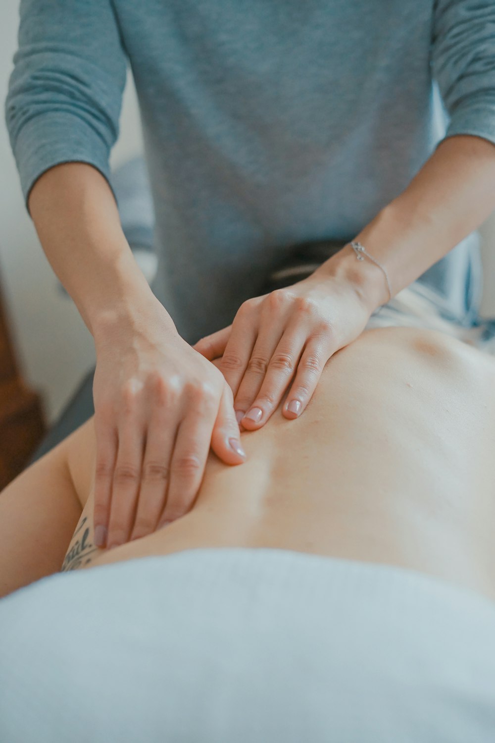 Therapist performing a relaxing back massage with both hands